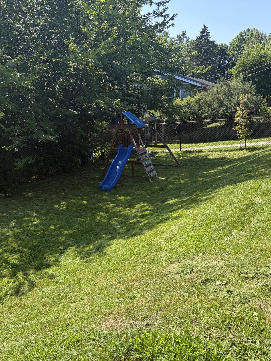 A freshly mown back garden in Guelph, Ontario, cut clean around a childrens playset